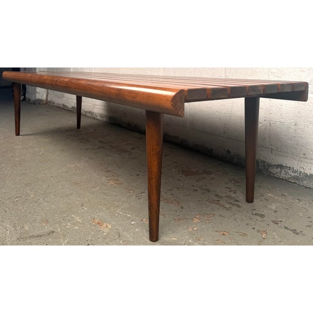 Clean lines, warm tones, and functional elegance come together in this classic Mid-Century Modern walnut slat bench, a...