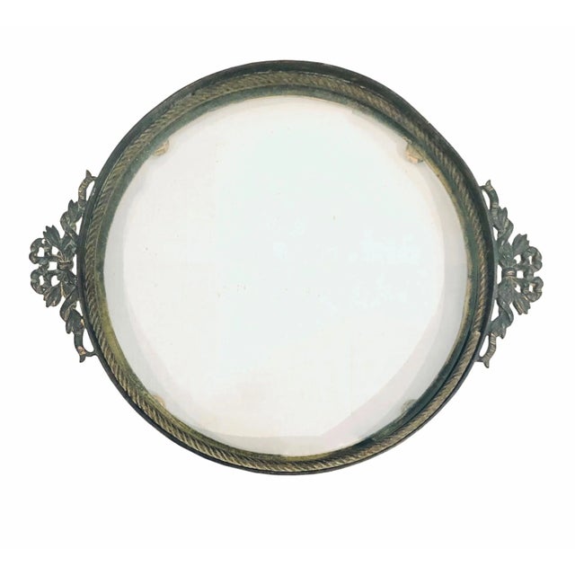 A very pretty French glass plateau. Bronze doré bow and neo-classical design around the edge sitting on little ball feet....