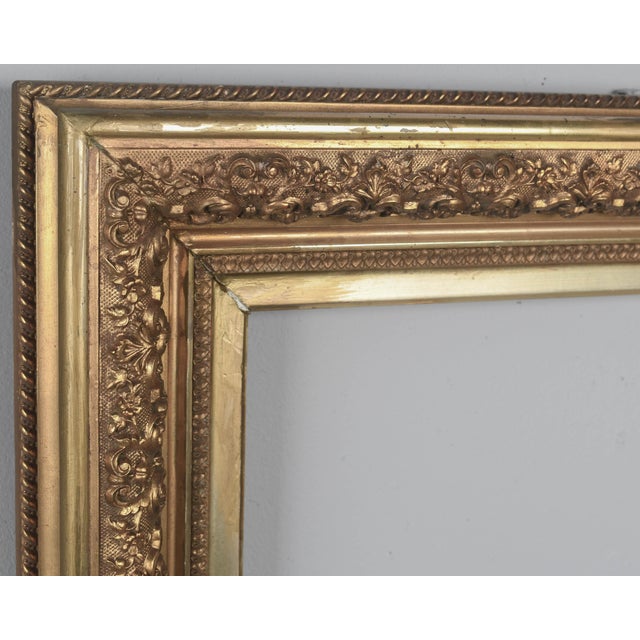 A 19th Century French giltwood picture frame with floral relief decoration and outer rope border. Warm gilt finish is in...