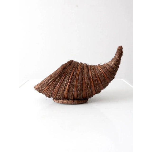 This vintage cornucopia basket embodies the timeless symbol of the horn of plenty, expertly woven in natural fibers over a...