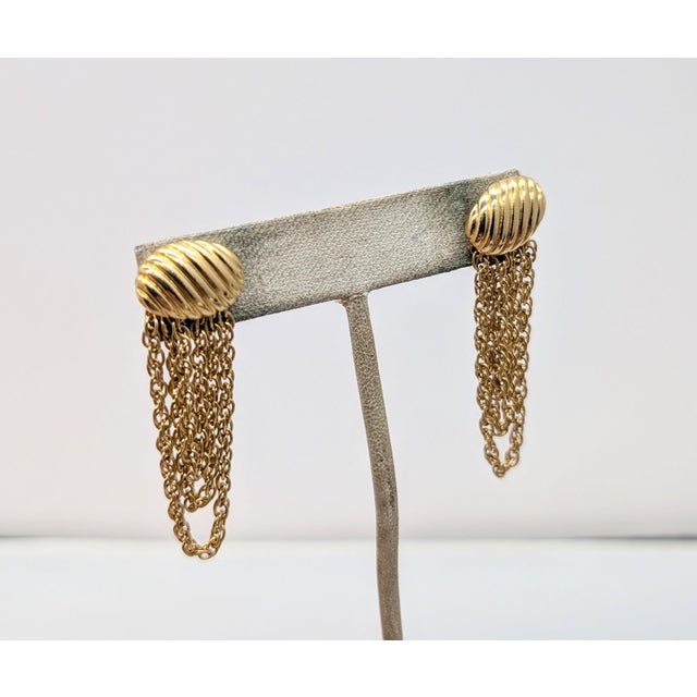 1970s oval ribbed goldtone top with goldtone looped fringe pierced push back earrings. Marked "MONET" around the base of...