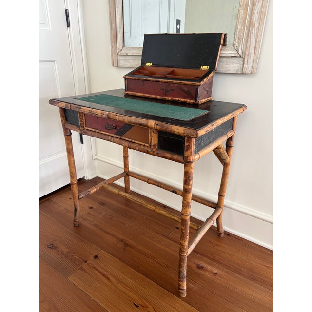 A wonderful antique bamboo writing desk with single lacquered drawer and rare storage cubby. Hand painted and embossed...