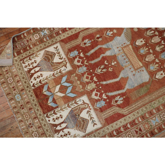 A fine rust colored Caucasian rug depicting a large light blue colored horse and 4 roosters dated 1948. Measures: 4'3" x...