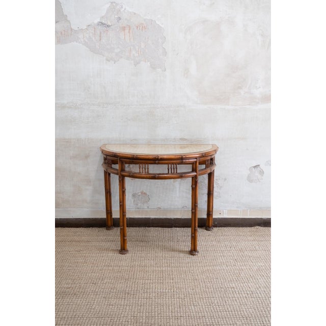 Pair of Faux Bamboo Demi-Lune Consoles – 1970s Turned wood structure with a faux bamboo finish, featuring a glass top and...