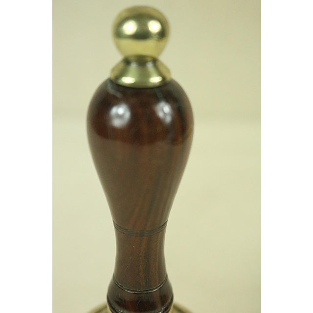 A late 19th century English hand bell with with a decorative wooden handle probably lignum vitae or rosewood. The handle...