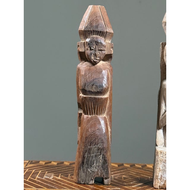This pair of hand carved wooden figures represents folk art traditions from Southeast Asia. The whitewashed example,...