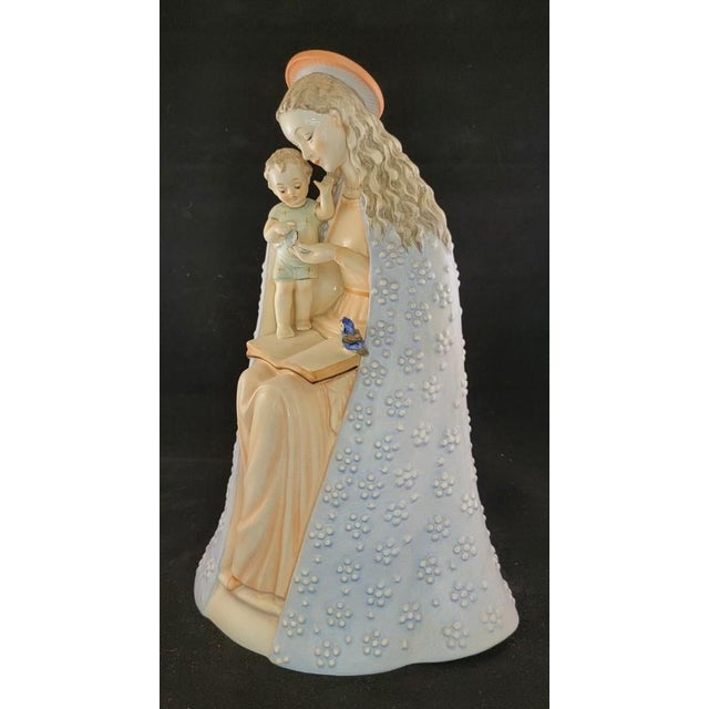 The M.J. Hummel "Flower Madonna" (cataloged as HUM 10) is a traditional Bavarian folk art-inspired porcelain figurine...