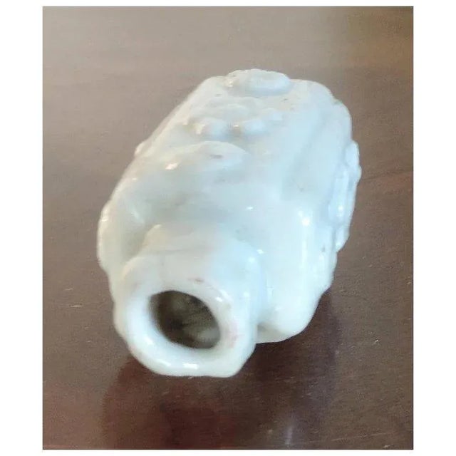 Antique 18th c. Chinese white porcelain octagonal snuff bottle with relief panels of flower heads. Ruyi at either side of...