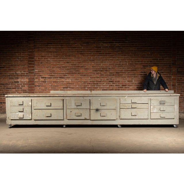 Extraordinary, nearly sixteen-foot-long industrial shop cabinet constructed in heavy pine and plywood with a thick, paint-...
