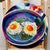 This artwork presents a vibrant depiction of crispy eggs, rendered in a lively color palette that emphasizes the glossy...