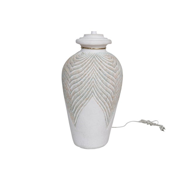 A postmodern urn shaped table lamp made of plaster. A beveled neck is decorated with a brass ring. Shoulders are embossed...