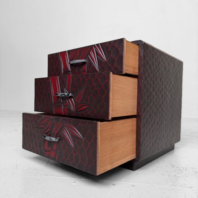 Decorative Japanese storage cabinet in Kamakura-bori, fitted with three drawers and richly carved with a bamboo motif...