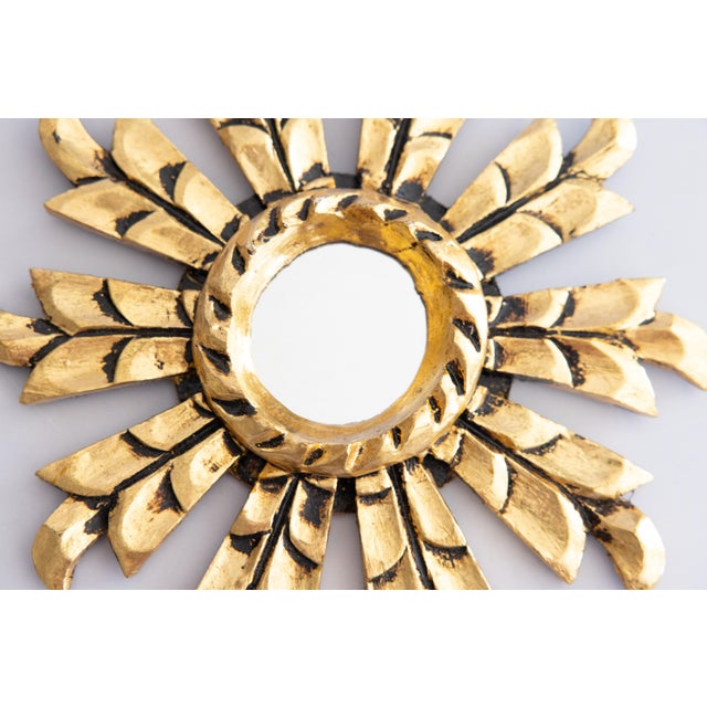 A charming petite Mid-Century Italian giltwood sunburst or starburst mirror with lovely gilt patina and finely carved...