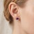 Elevate your everyday look with a touch of royal sophistication. These striking geometric stud earrings feature a...