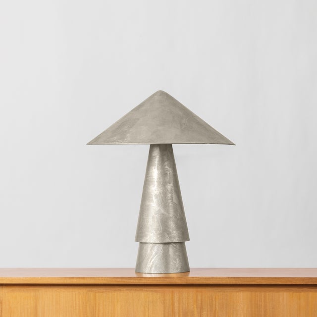 Inspired by antiquities, the Foxton table lamp cuts a bold figure with artistic geometry and textural finishes. The...