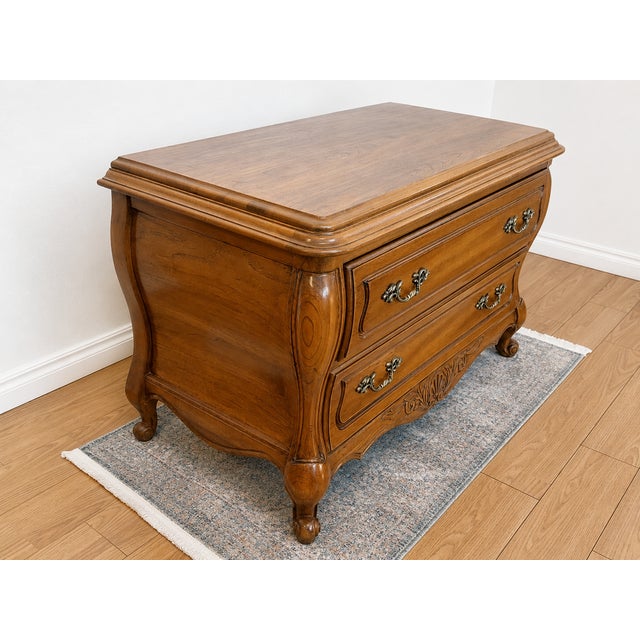Crafted by Hickory Furniture, this vintage French Provincial bombe chest showcases the quality construction and timeless...