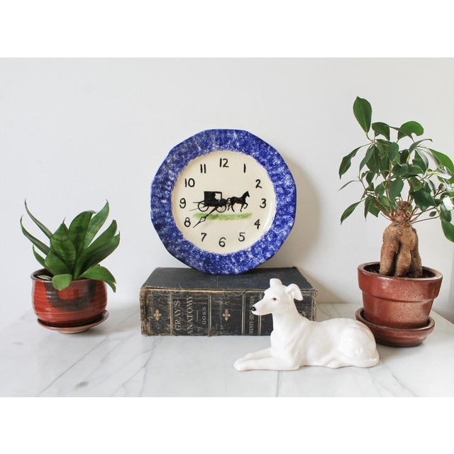 Vintage hand painted spongeware wall plate converted into a wall clock. Features horse drawn carriage scene. Makers mark...