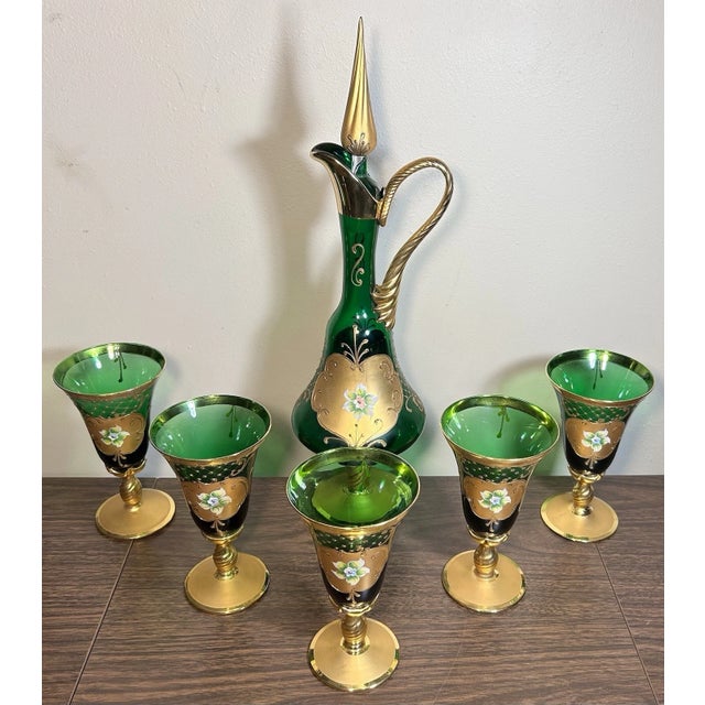 This is a Vintage Venetian Tre Fuochi Gilded Emerald Green Glass Decanter/Goblets Set. The decanter measures 19 1/4” tall....