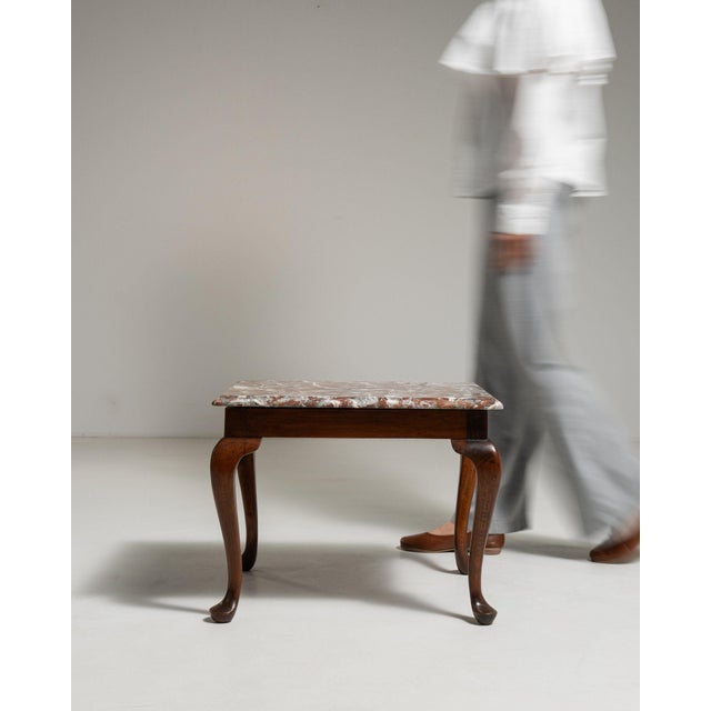 This side table carries genuine presence, its rose/pink marble top, dark walnut cabriole legs immediately setting the tone...
