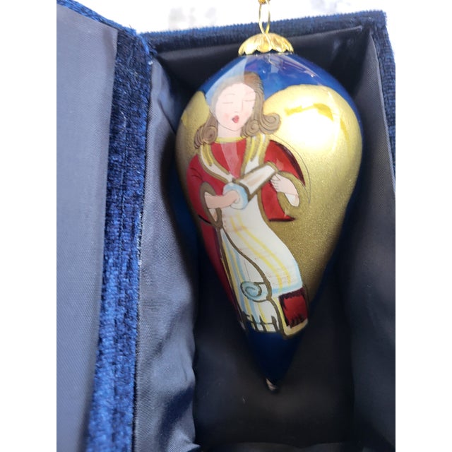 This is a large glass ornament. It is reverse painted, featuring a beautiful angel with golden wings.. The box is included.