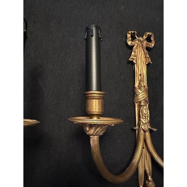 Presented here are a pair of exquisite late 20th-century brass wall sconces, tastefully adorned with captivating bows,...