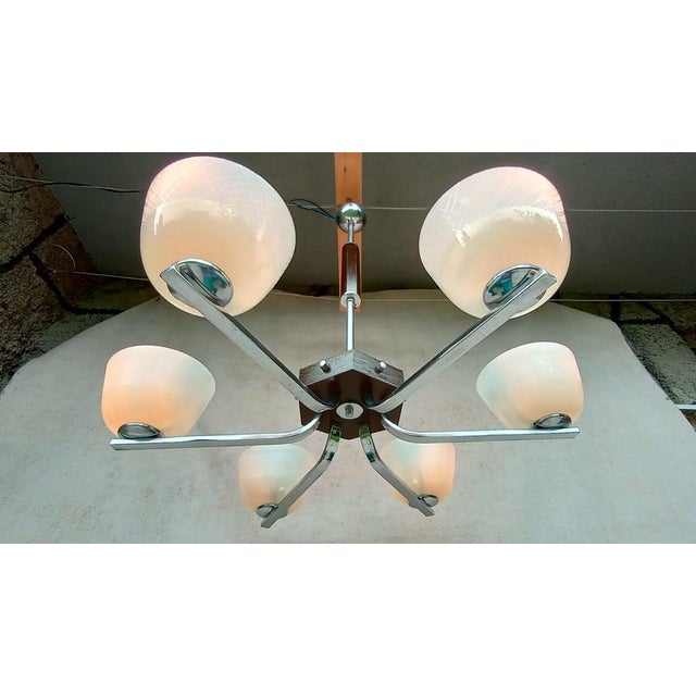 Very nice chandelier in art deco style. It has a chrome holder with a slight patina. 6 light elements made of cream glass...
