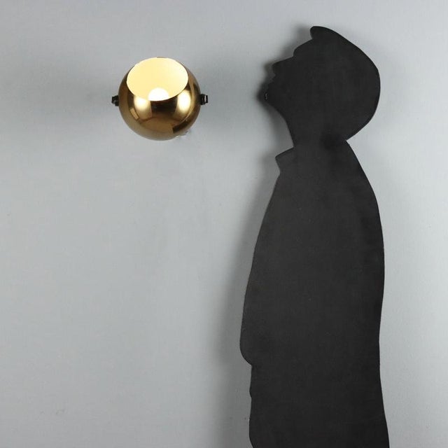 Adjustable wall lamp from the 1960s, made in Italy. The design features a spherical metal diffuser with a gold finish that...
