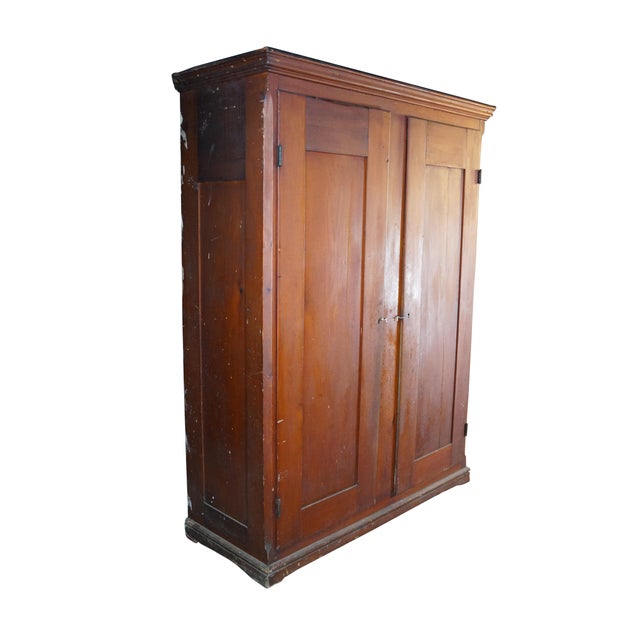 This antique wardrobe is a rustic, country-style armoire crafted from solid poplar wood, showcasing a warm, honey-toned...