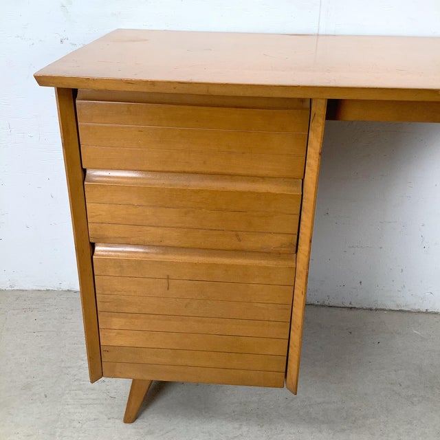 This mid-century modern student desk is attributed to Baumritter and reflects the practical elegance of late 1950s...