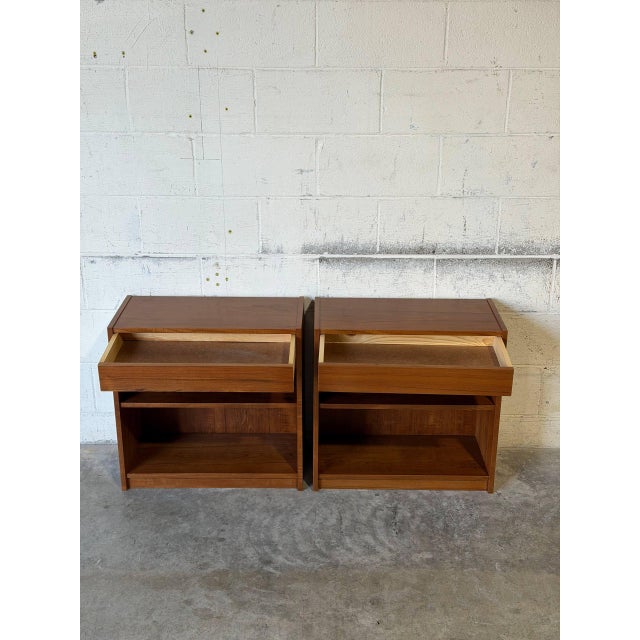 Clean linear silhouette features open shelving compartments beneath top drawers for versatile storage. Showcases warm teak...