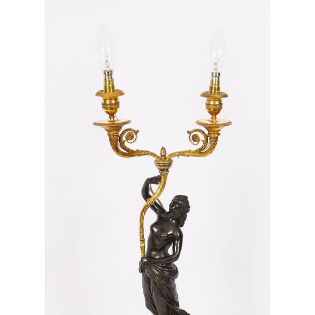 This is a very fine antique pair of French bronze and ormolu figural candelabra, circa 1820 in date. This finely cast pair...