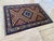 This vintage rug is hand-knotted in wool, woven in the Kazak Caucasian tribal design tradition, in a sunburst pattern of...