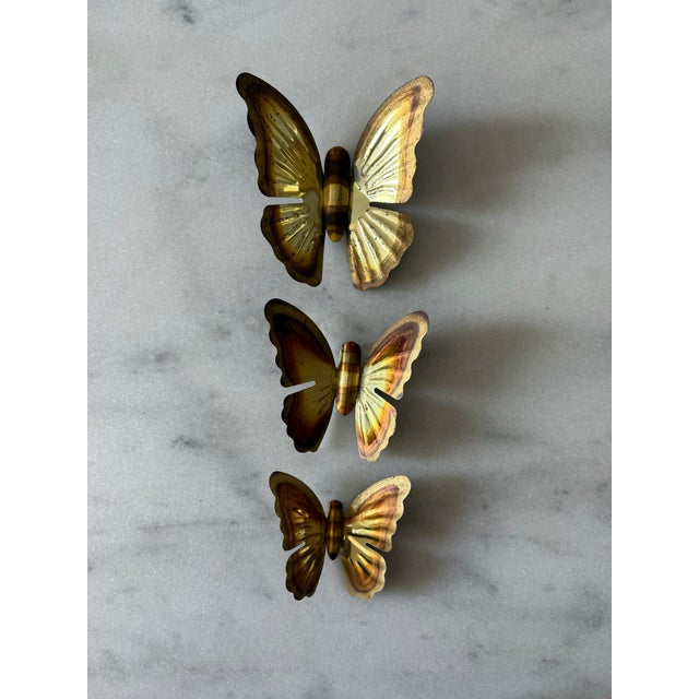 Set of 3 vintage brass butterfly wall hangings featuring a classic mid century design with detailed embossed wings. Set...