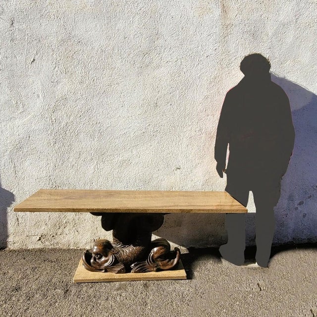 Large carved wooden coffee table featuring two dolphins, with a marble base and top. Good overall condition, with some...