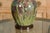 A green glazed 1920s pottery table lamp with raised floral motif, brown accents and circular wooden base. Evoke a sense of...