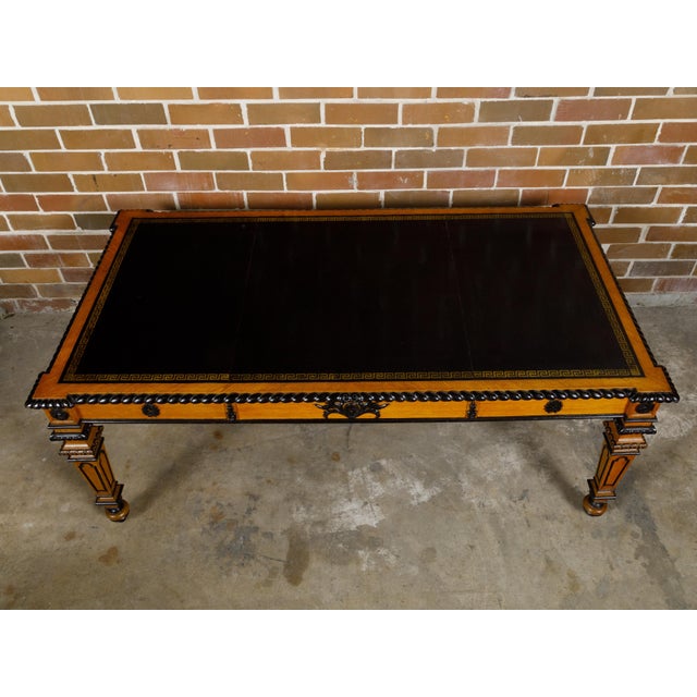 An English oak desk from the 19th century with ebonized accents, carved floral motifs and Greek Key frieze. This 19th-...