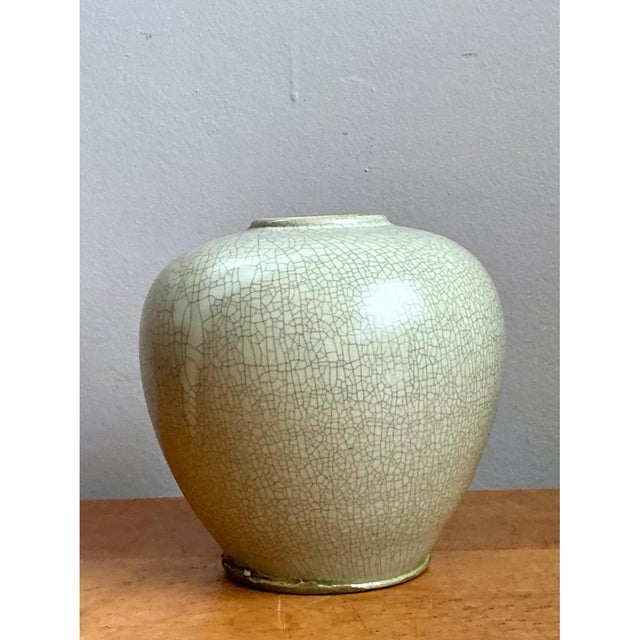 This vase presents a soft, rounded silhouette rooted firmly in classical Asian ceramic tradition, its body swelling...