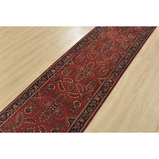 A traditional Sarouk runner hand-knotted with an all-wool pile on a cotton foundation. This finely woven oriental rug...