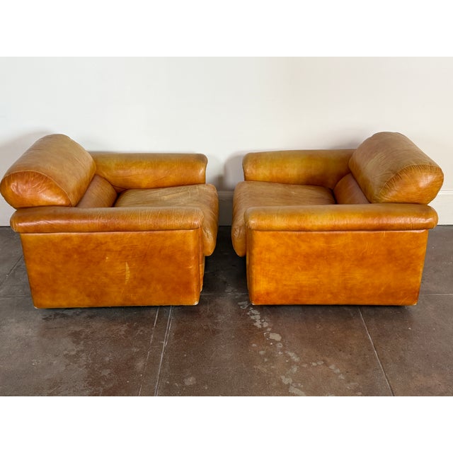 Stunning pair of vintage Italian lounge chairs from the 1970s, upholstered in rich cognac leather with a beautifully...