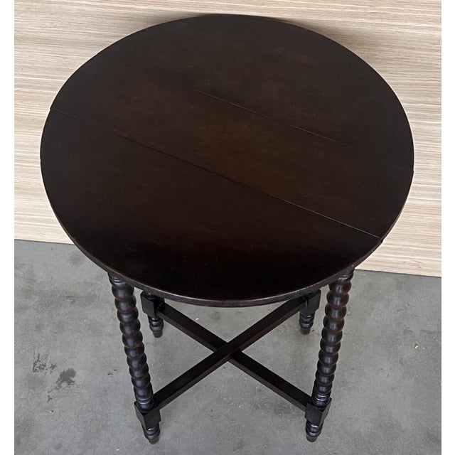 Round Folding oak side table with Solomonic legs and carved top and carved edges. The table has six legs when its opened...