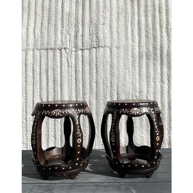 This stunning pair of vintage Asian low stools is a true celebration of craftsmanship and artistry. Each stool features a...