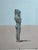 This artwork presents a solitary figure standing in serene isolation against a vast, minimalist backdrop. The figure,...