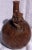 A charming mold-formed pottery vessel with a planar base, a spherical body with a bulbous shoulder, a stirrup-shaped...