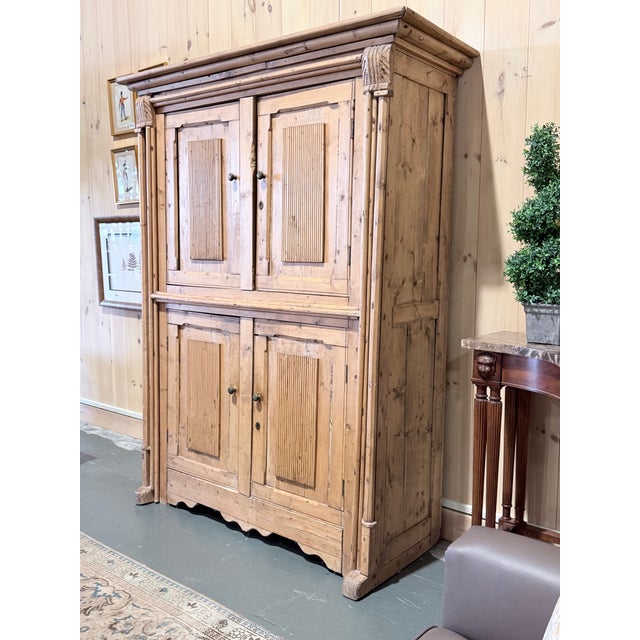 A remarkable antique English pine cupboard showcasing the honest character and enduring craftsmanship of traditional...