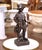 This charming mid-century French bronze sculpture depicts a young hunter in rustic attire, modeled in the sentimental and...