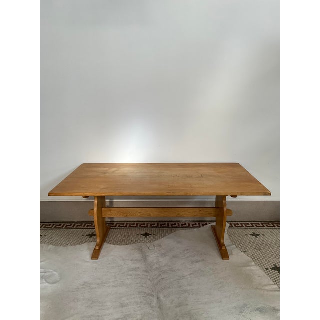Handsome oak trestle dining table crafted in the manner of Henning Kjærnulf Comes with two leaves, each measuring 19.75”...