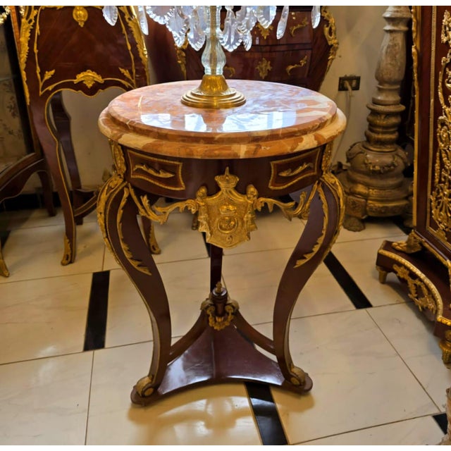 Elevate your space with this elegant French Empire Side Table, featuring a luxurious marble top, graceful curved legs, and...