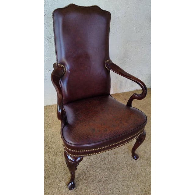 Beautiful restored leather mahogany open arm chair. The leather is secured with brass accent studs aka tack head trim....