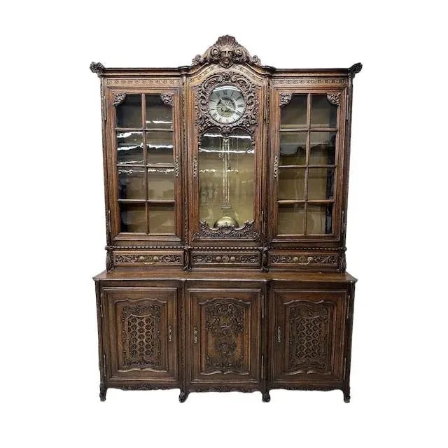 This very unique piece is a French carved oak vaisselier . It has hand blown glass doors flanking a round clock in the...