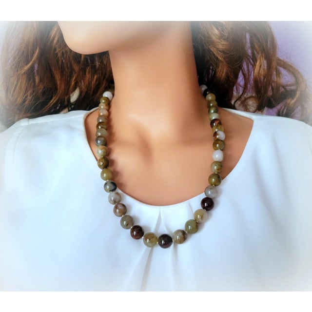 The length of the necklace is 24 inches (61 cm). The size of the smooth round beads is 12 mm. The necklace is fastened...